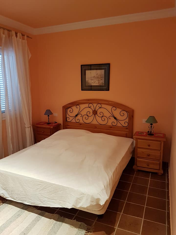 Ein Schlafzimmer mit einem Bett, Nachttischen und einem Bild an der Wand.
