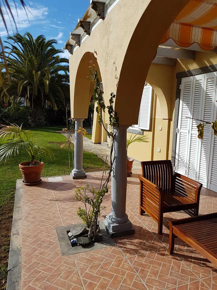 Eine Terrasse mit Stühlen und einem Tisch unter einer Markise