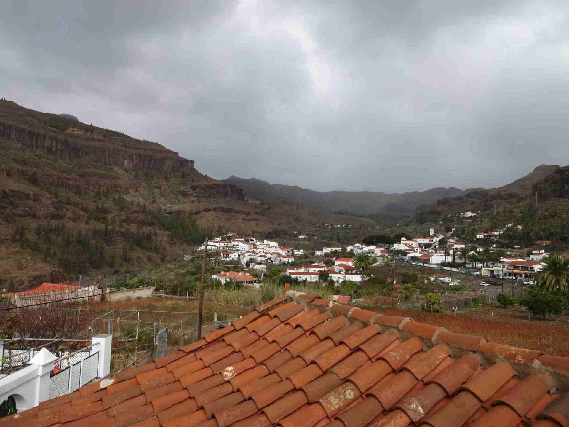 Blick vom Dach einer kleinen Stadt in den Bergen an einem bewölkten Tag.