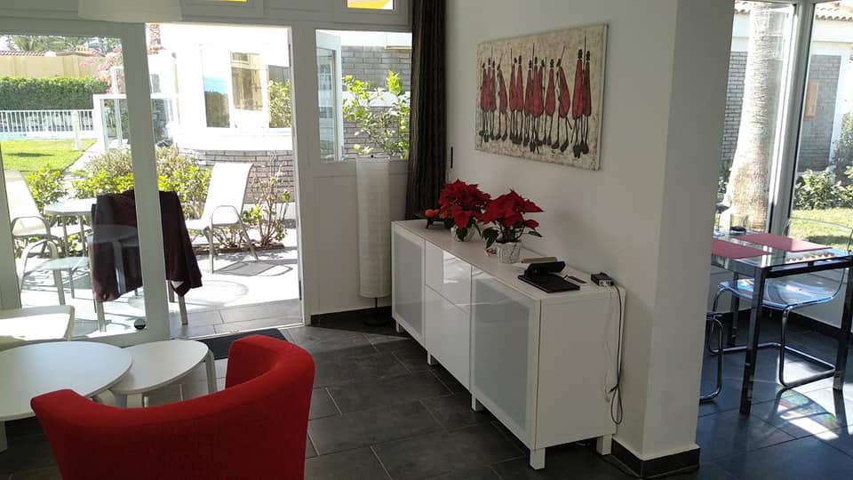 Ein Wohnzimmer mit einem roten Sessel und einer weißen Kommode.