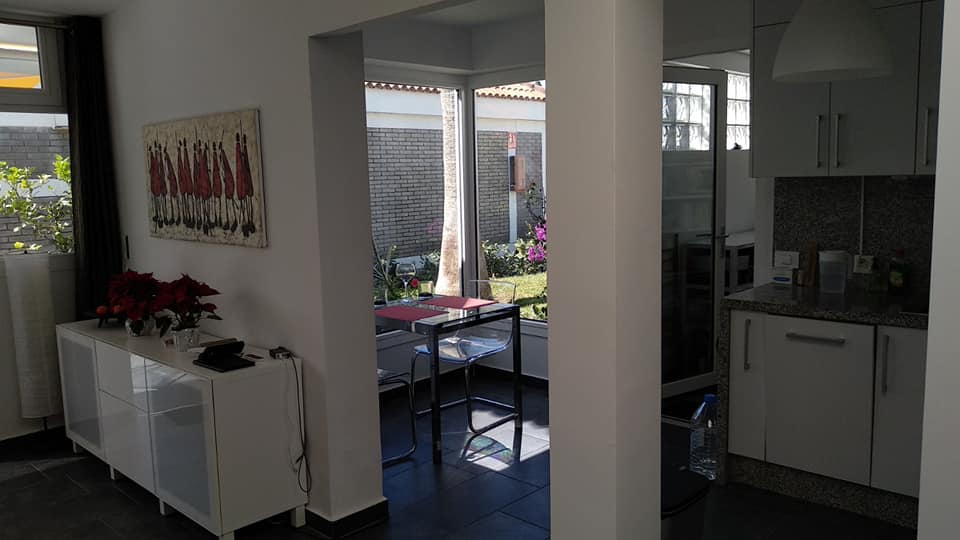 Ein Wohnzimmer mit Tisch und Stühlen und eine Küche.