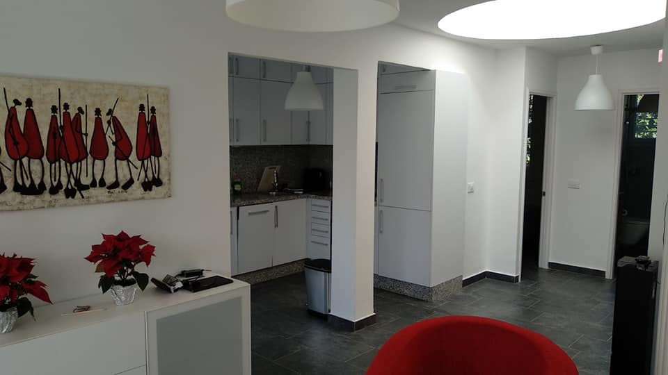 Ein Wohnzimmer mit einem roten Stuhl und einem Gemälde an der Wand