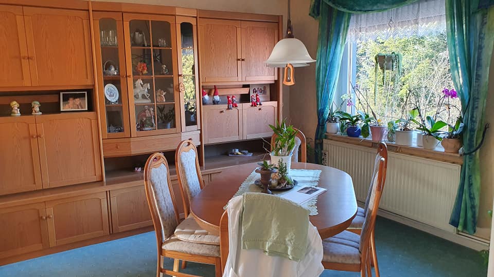 Ein Esszimmer mit Tisch und Stühlen und einem Fenster.