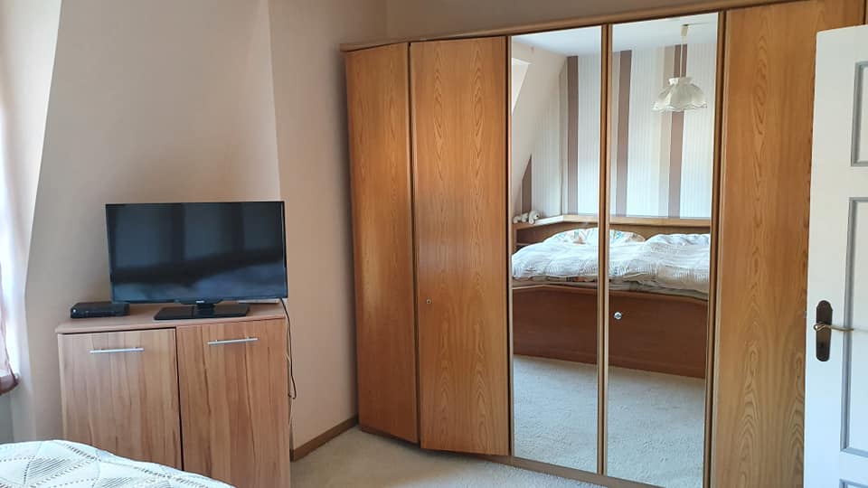 Ein Schlafzimmer mit großem Kleiderschrank und Flachbildfernseher.