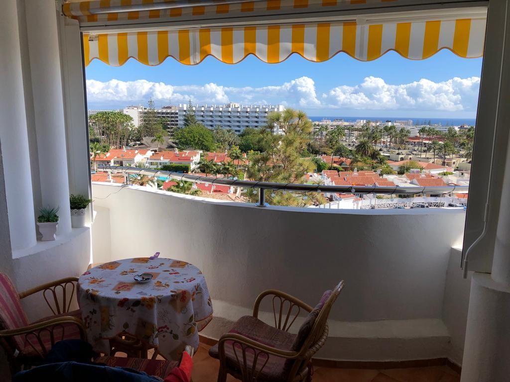 Ein Balkon mit Tisch und Stühlen und Blick auf die Stadt