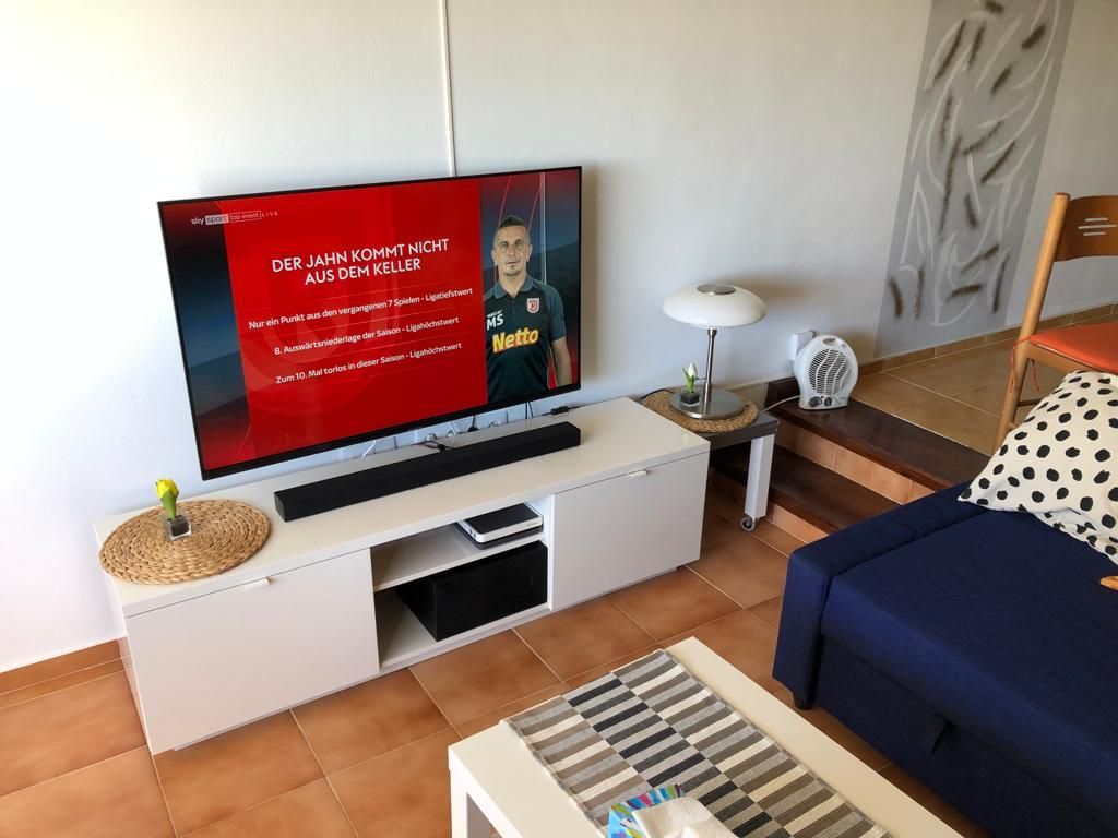 Ein Wohnzimmer mit Flachbildfernseher und Couch.