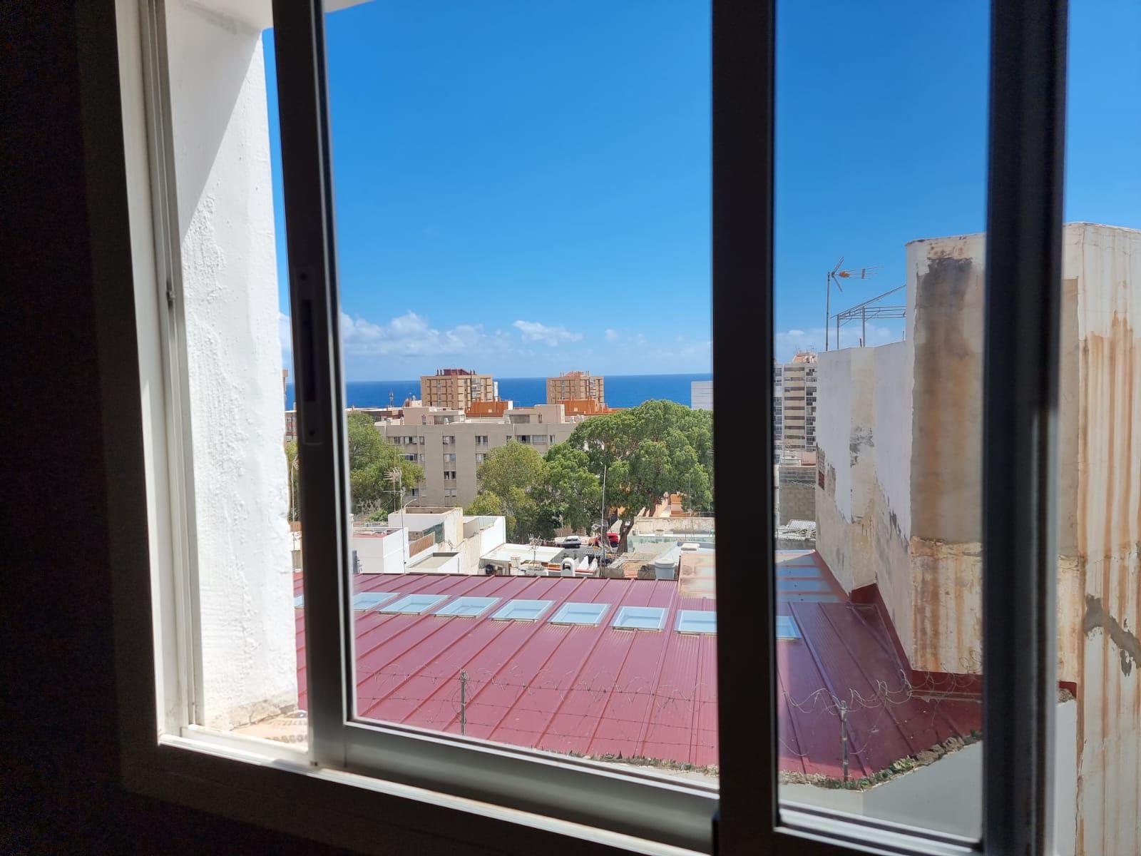 Ein Fenster mit Blick auf die Stadt und das Meer