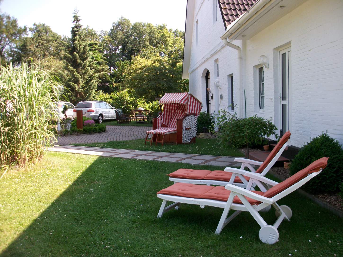 Ein weißes Haus mit Gartenstühlen davor