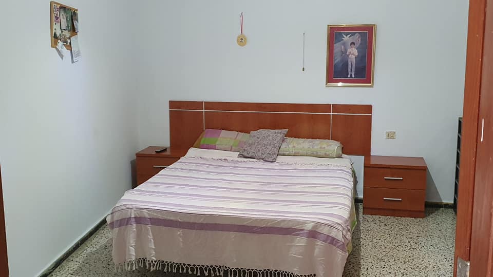 Ein Schlafzimmer mit einem Bett, Nachttischen und einem Bild an der Wand.