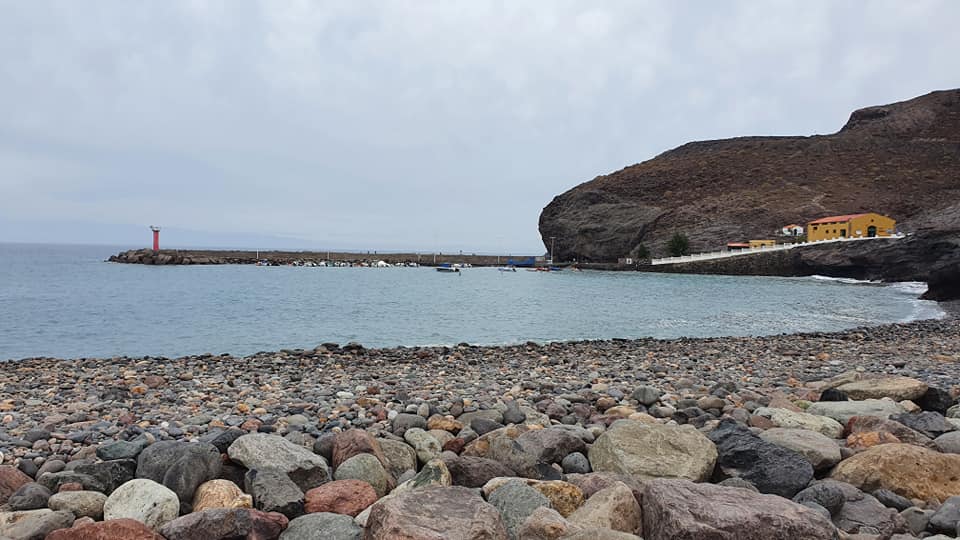 Ein felsiger Strand mit einem Leuchtturm in der Ferne