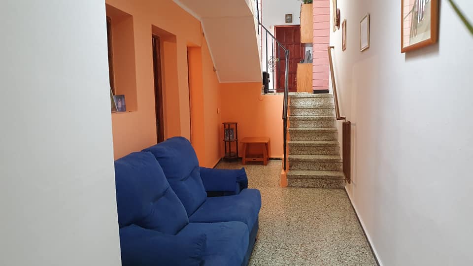 Eine blaue Couch steht in einem Flur neben einer Treppe