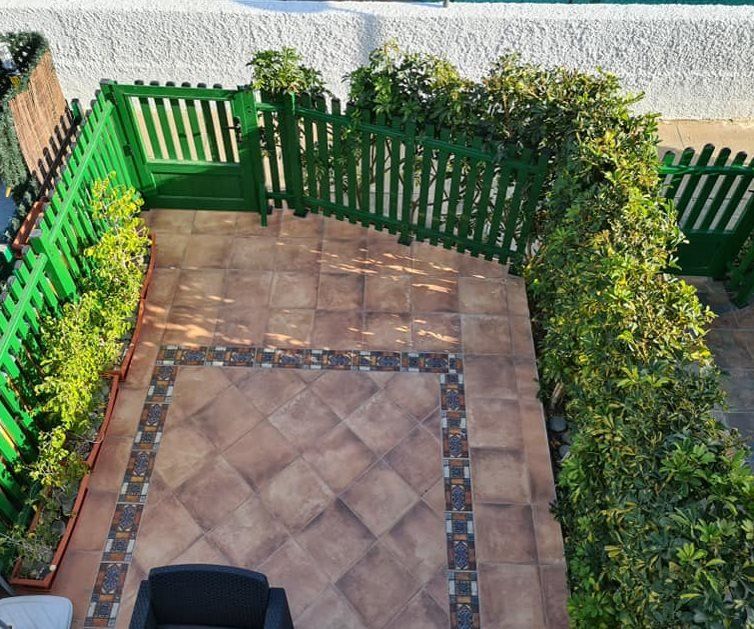 Eine Luftaufnahme einer Terrasse mit einem grünen Zaun