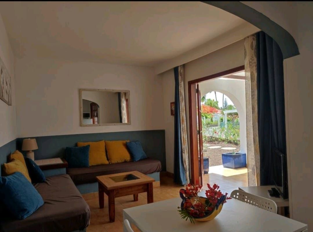 Ein Wohnzimmer mit Couch, Tisch und Spiegel