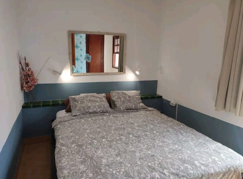 Ein Schlafzimmer mit einem großen Bett und einem Spiegel an der Wand.