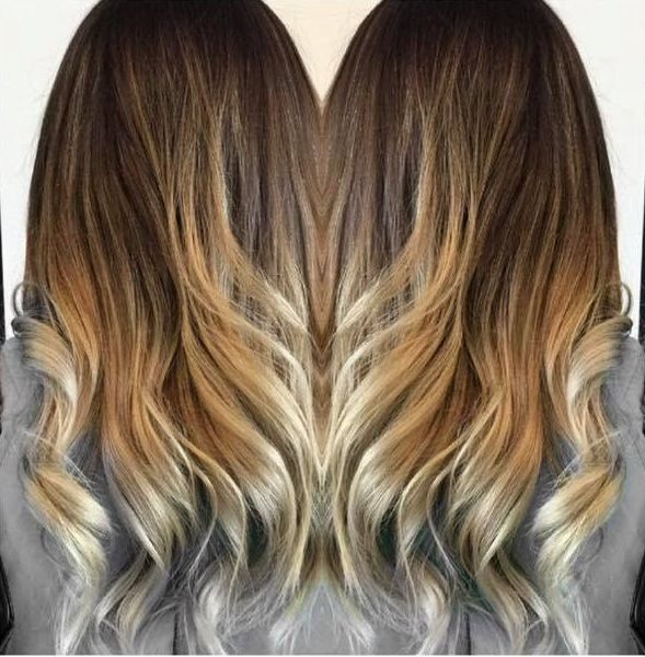 A Woman With Long Brown and Blonde Hair is Wearing a Gray Shirt — Xquisite Styles in Kiama, NSW