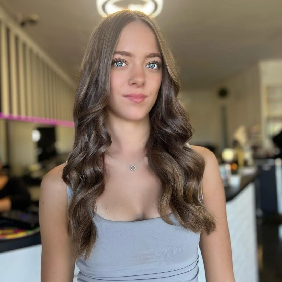 A Woman With Long Hair is Wearing a Gray Tank Top and a Necklace — Xquisite Styles in Mount Warrigal, NSW