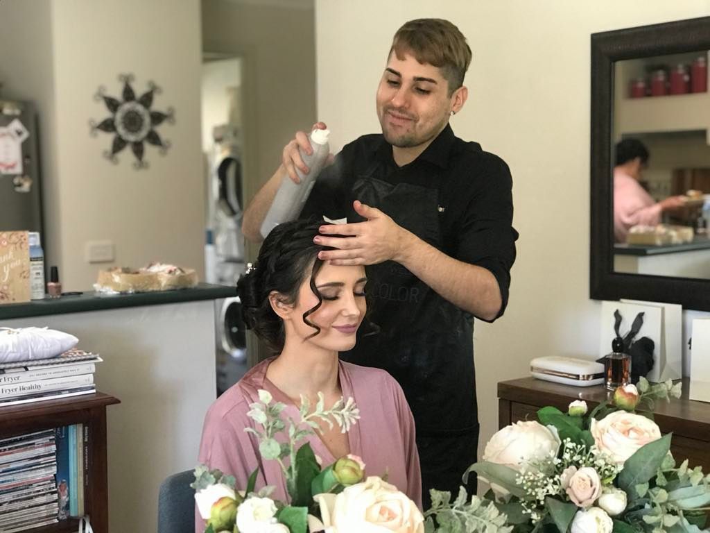A Man is Spraying a Woman 's Hair — Xquisite Styles in Albion Park, NSW