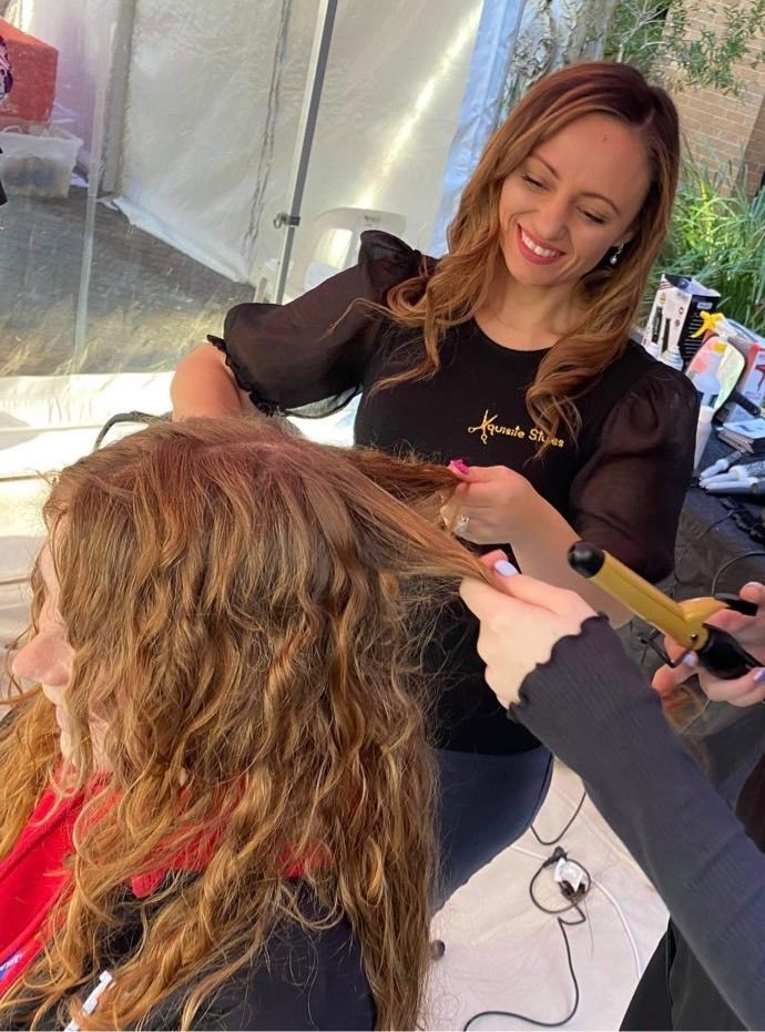 A Woman is Getting Her Hair Straightened by a Hairdresser — Xquisite Styles in Mount Warrigal, NSW
