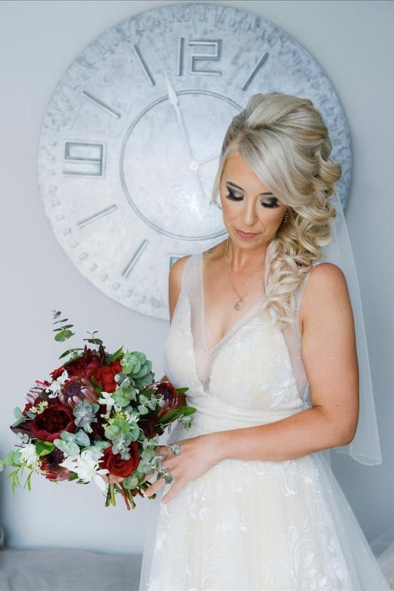 A Woman in a Wedding Dress is Holding a Bouquet of Flowers — Xquisite Styles in Albion Park, NSW