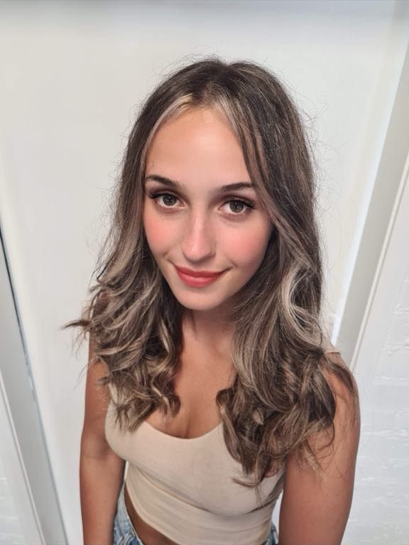 A Woman With Long Hair Smiling — Xquisite Styles in Albion Park, NSW