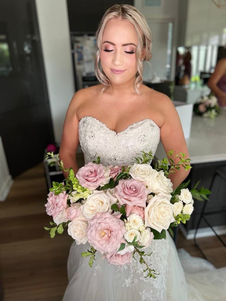 A Bride in a Wedding Dress is Holding a Bouquet of Pink and White Flowers — Xquisite Styles in Mount Warrigal, NSW