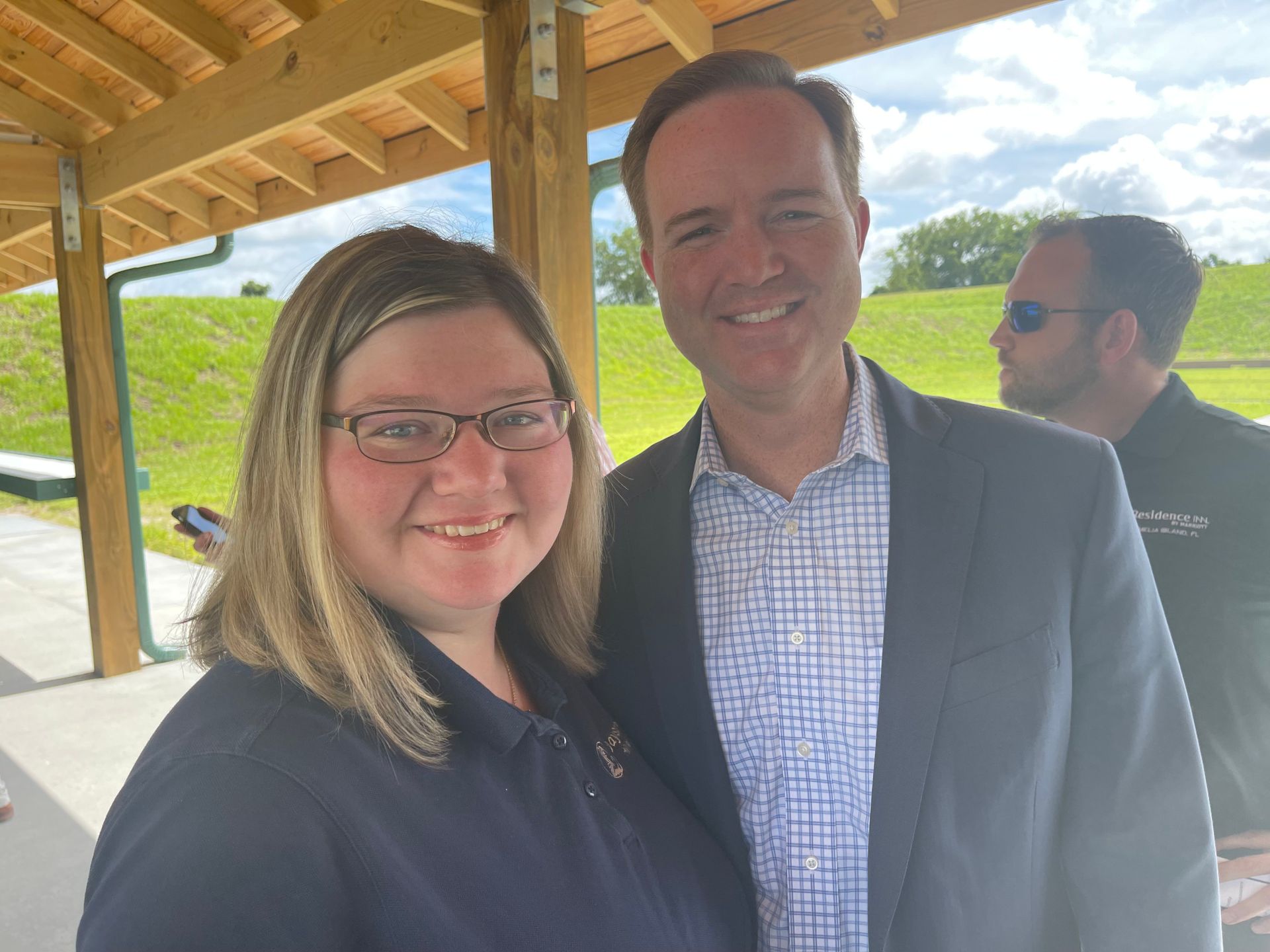 A man and a woman are posing for a picture under a canopy.