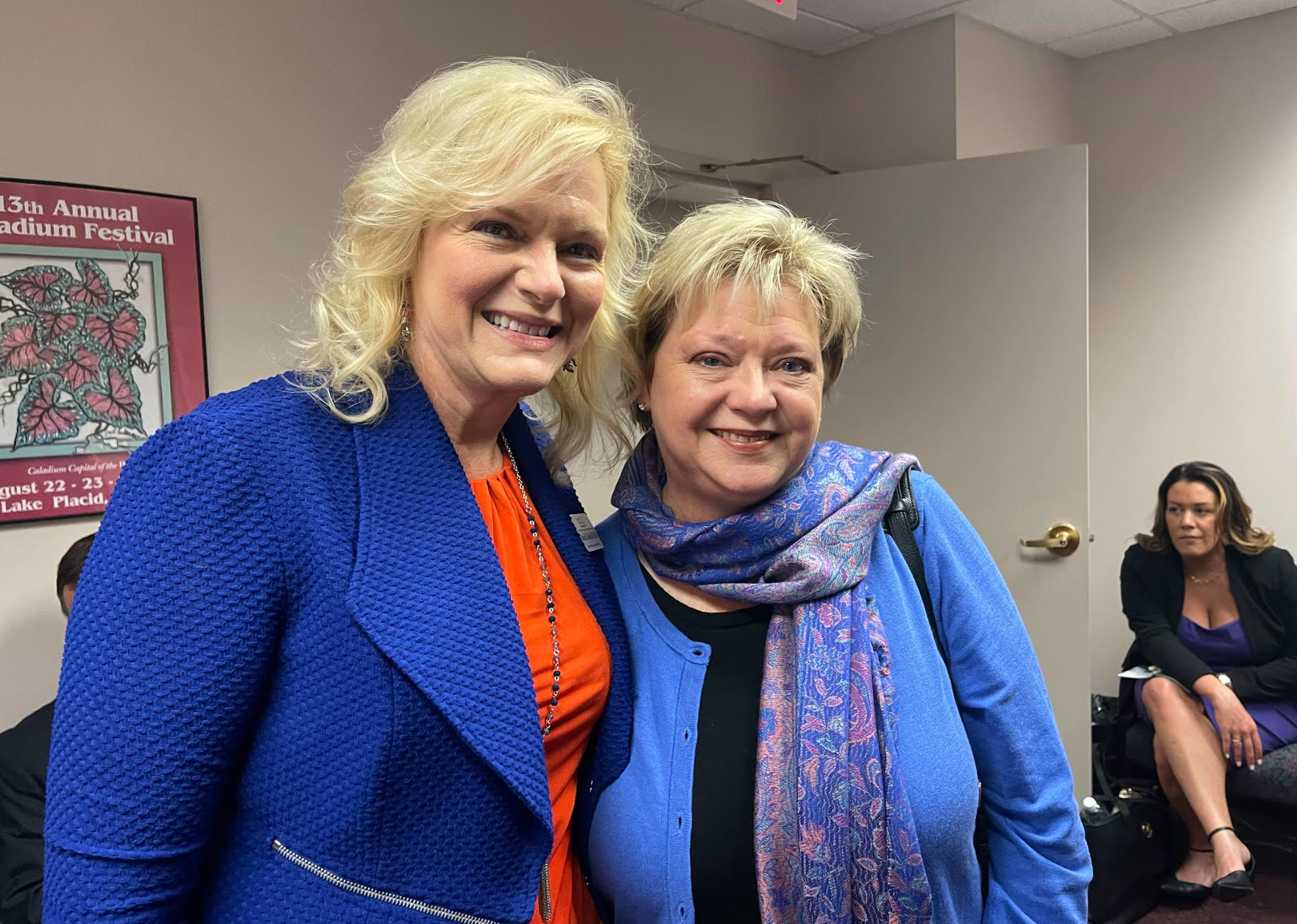 Two women are posing for a picture together in a room.
