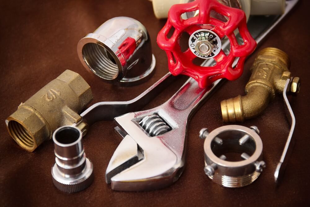 Wrench Surrounded by Plumbing Parts — Professional Plumber in Toowoomba