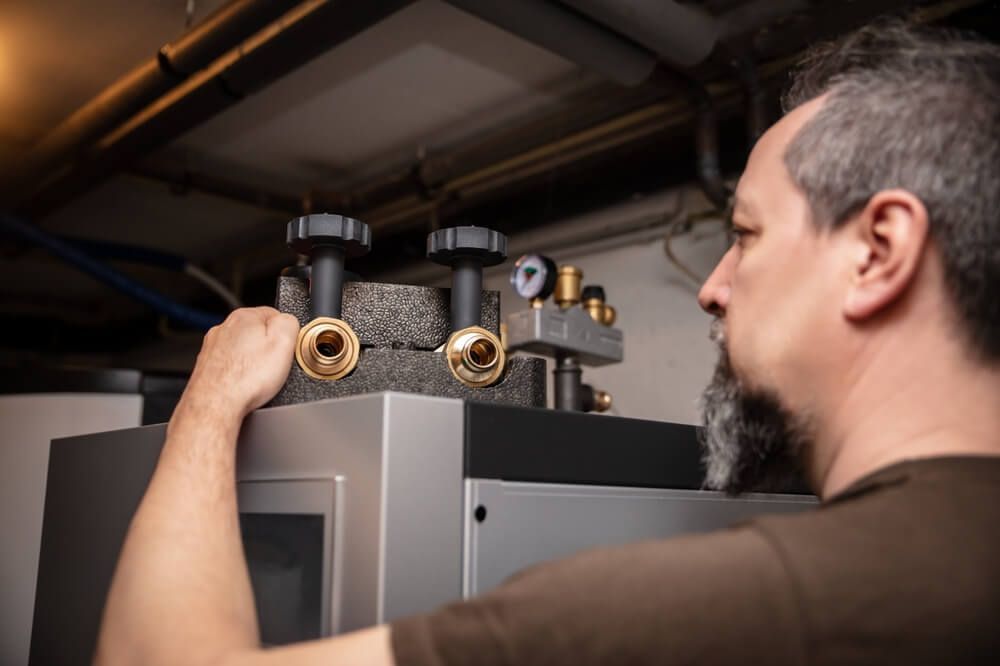 Man Working on A Machine in A Room — Professional Plumber in Toowoomba