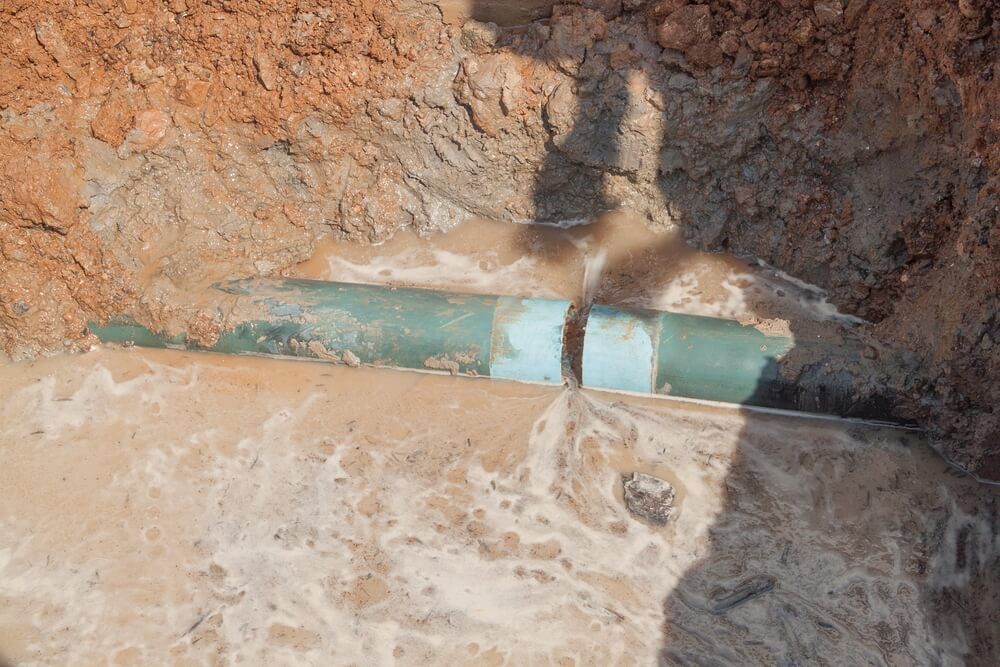 Green Pipe Laying in The Dirt in A Hole — Professional Plumber in Toowoomba