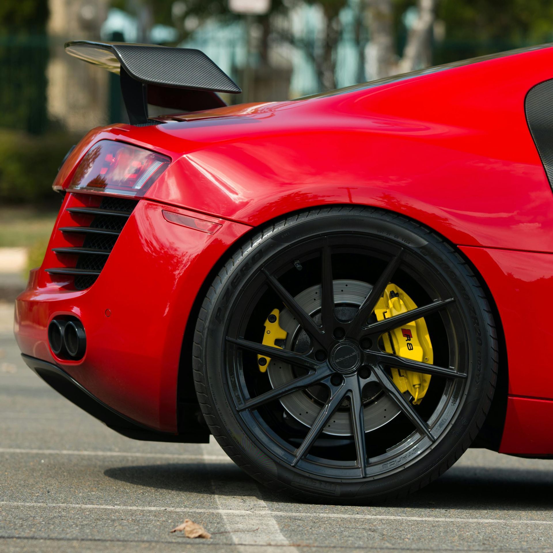 Red Audi R8 with black wheels and yellow brake calipers.