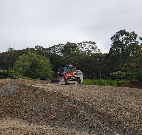 Red Excavator On Job Site — Stan Davies Excavations in Glendale, NSW