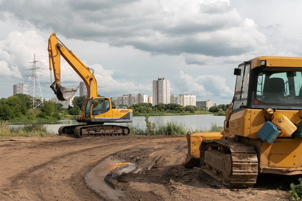 Excavator positioned near the river, ready for efficient and precise excavation work — Stan Davies Excavations in Newcastle, NSW