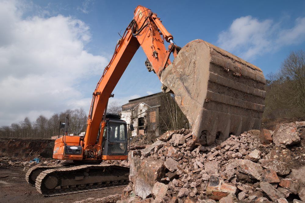 Excavator breaking debris with a fully extended bucket arm — Stan Davies Excavations in Lake Macquarie, NSW
