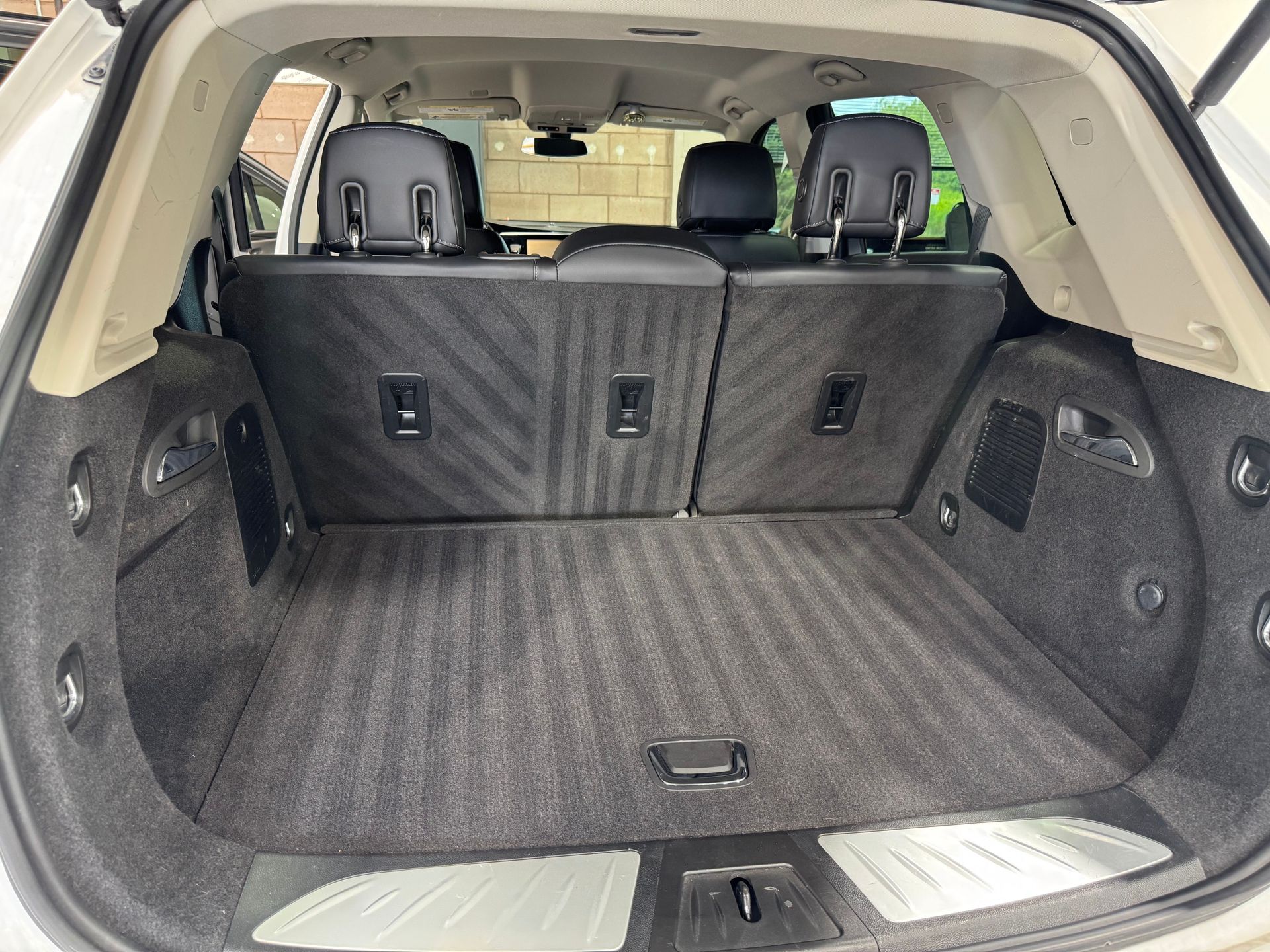 Clean, empty white SUV cargo area, gray carpet, black seats.