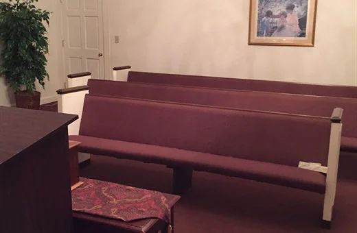 a church with purple benches and a picture on the wall