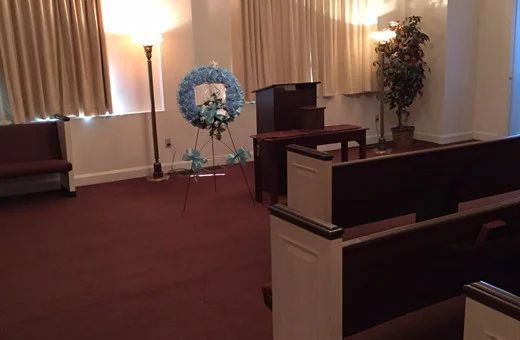 a funeral home with a wreath on the wall and a podium .