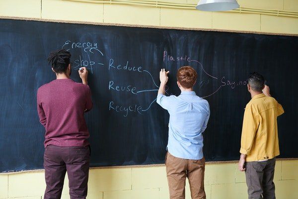 Adolescents writing on a blackboard