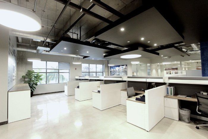 A large office with cubicles and a lot of windows
