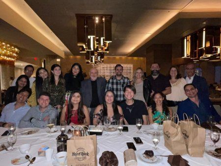 A group of people are posing for a picture at a table in a restaurant.