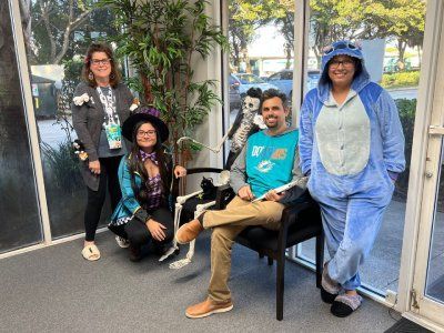 A group of people dressed in halloween costumes are posing for a picture.