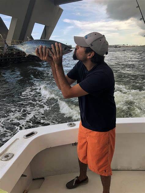 A man on a boat is blowing on a fish