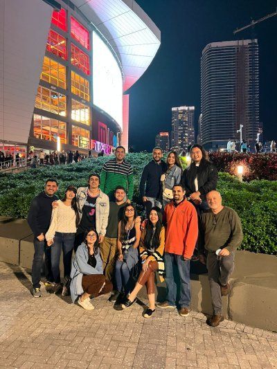 A group of people are posing for a picture in front of a building at night.
