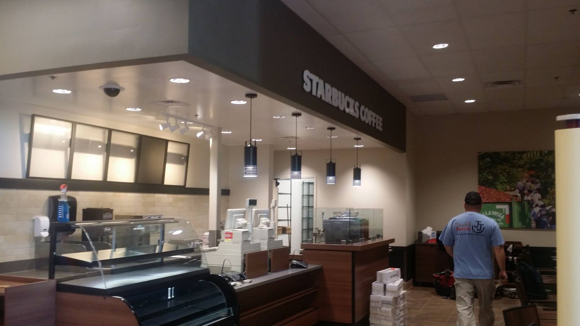 A man is walking through a starbucks coffee shop