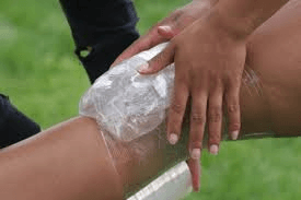a person is putting an ice pack on a person 's knee .