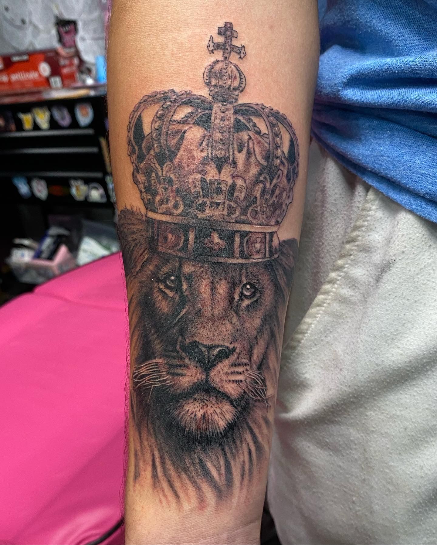 Detailed lion and crown forearm tattoo by a skilled tattoo artist in Raleigh NC tattoo shops.