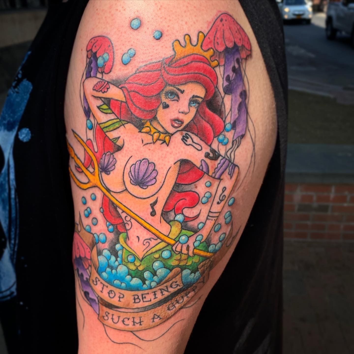 Vibrant little mermaid tattoo design on arm, created at one of the best tattoo parlors in North Carolina for colorful tattoos