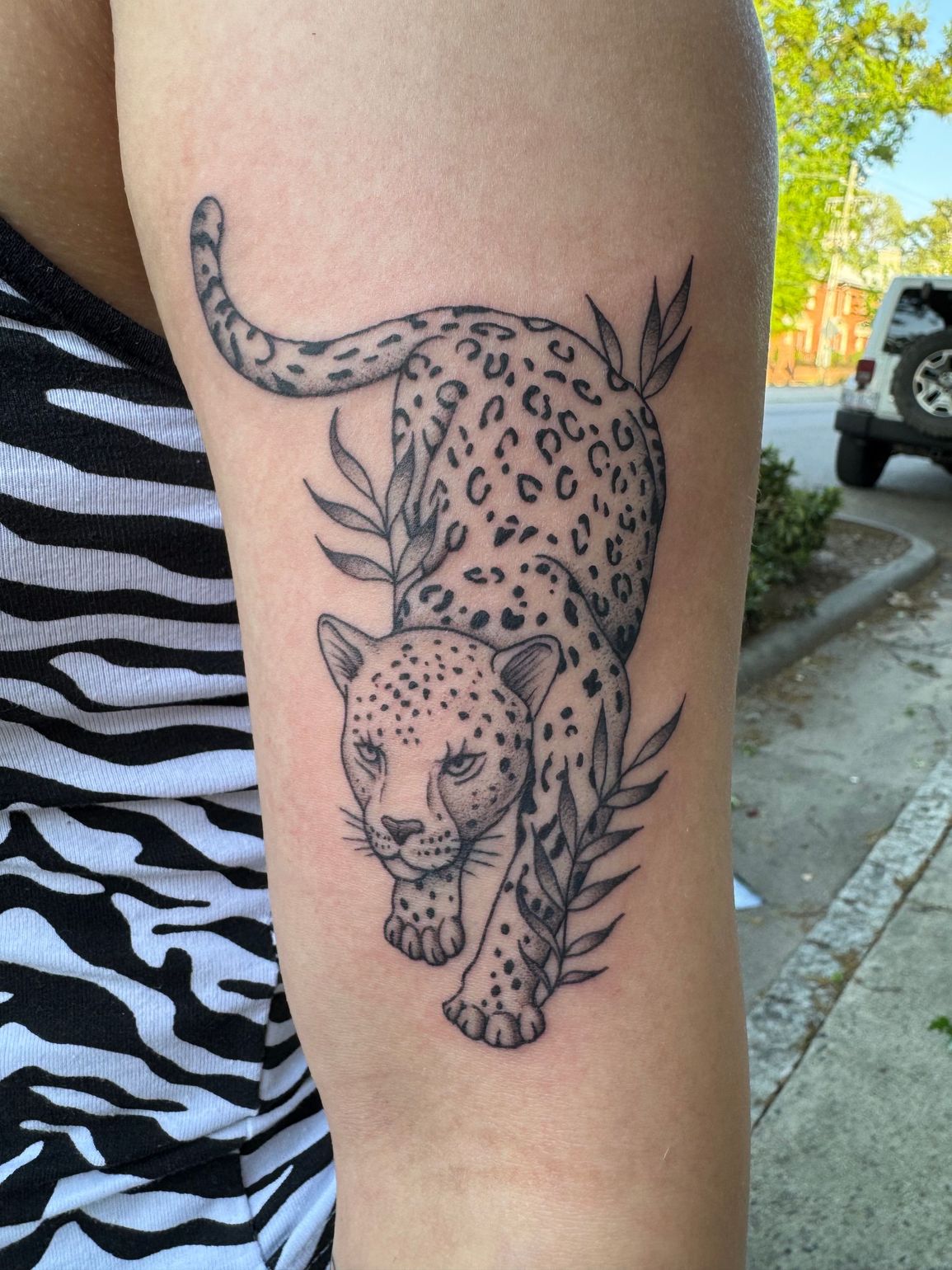 “Floral tattoo on forearm, pink shading with soft black lines.