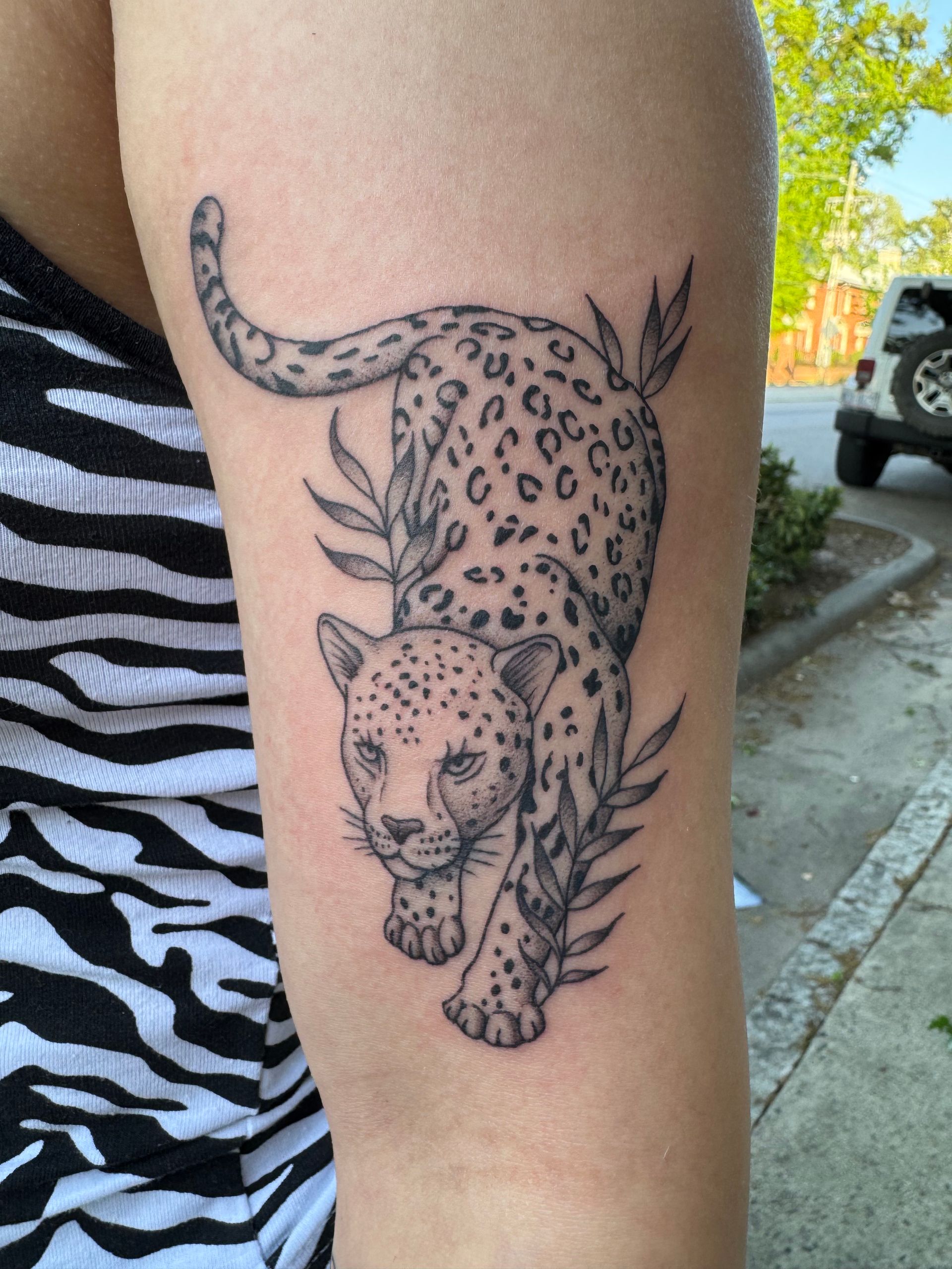 “Floral tattoo on forearm, pink shading with soft black lines.