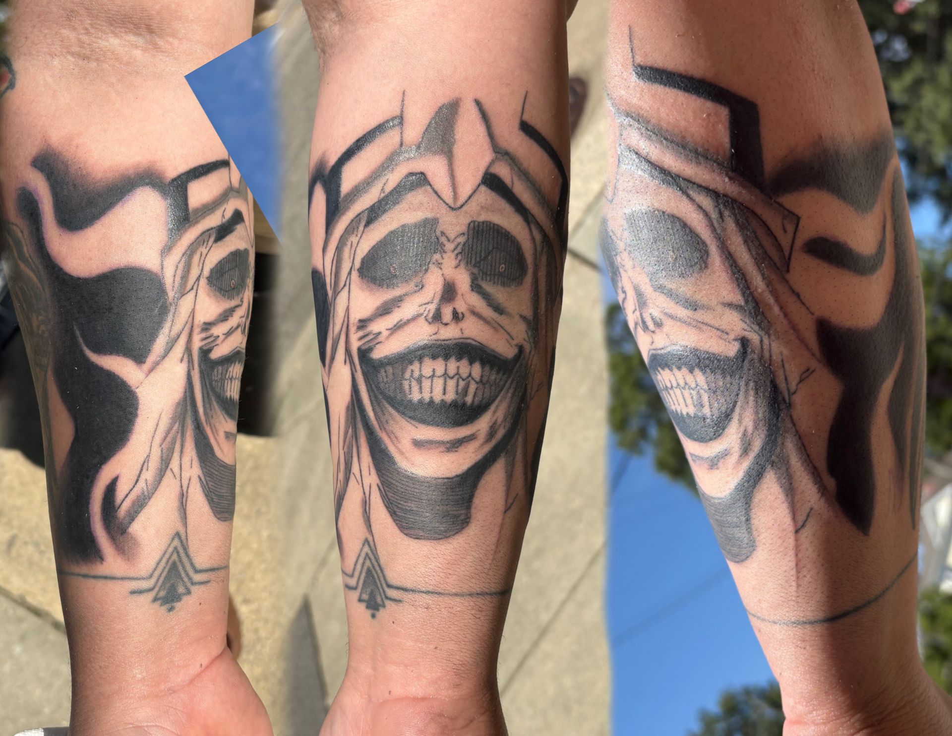 Tattoo of a grinning face with a crown design on an arm, with black shading and details.